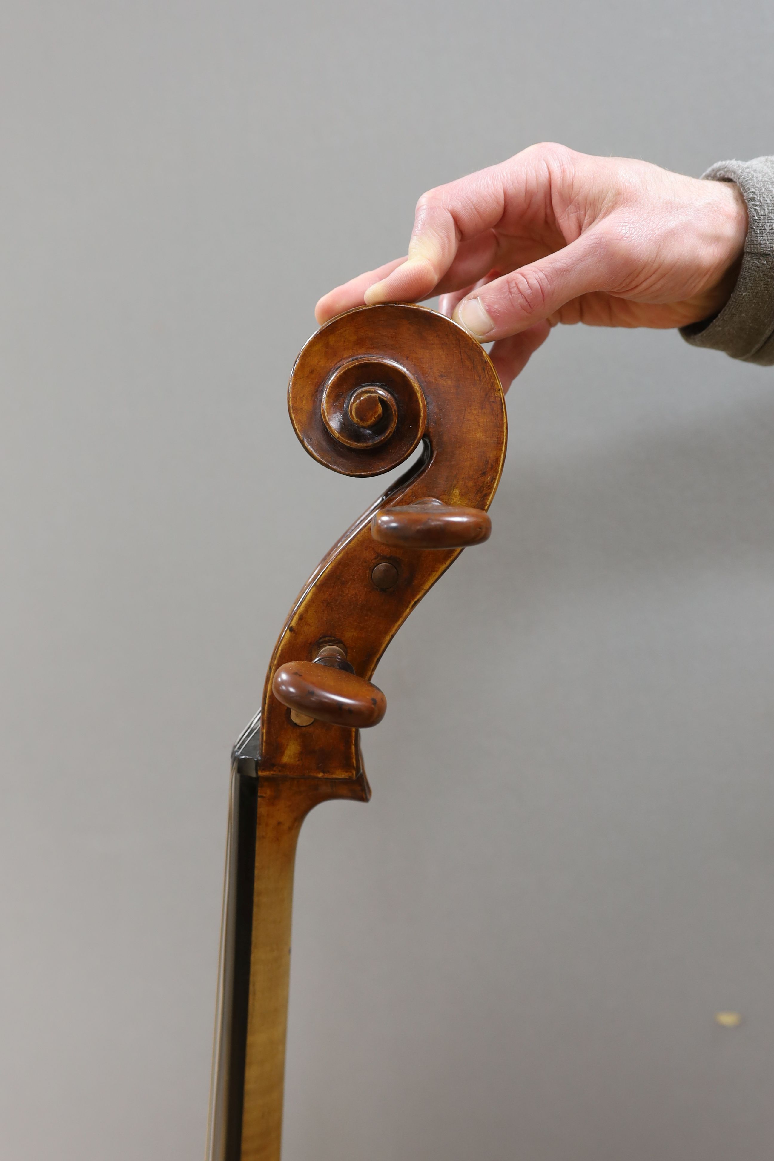 A cased early 20th century ‘cello, length of body 75.5cm, with two spare bridges, and spare strings